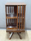 A mahogany revolving bookcase with two shelves raised on four legs,