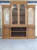A late 19th/20thC light oak, glazed breakfront bookcase with adjustable shelving,