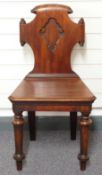A 19th century mahogany hall chair with scrolled decoration to back