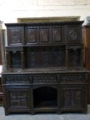 A 19thC carved oak three drawer dresser with carved panel back and dog kennel cubbyhole,