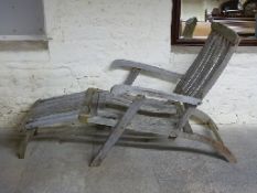 A teak or similar steamer chair with brass fittings