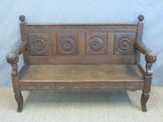 A 19thC carved oak and ash settle with owl head arm rests,