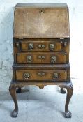 A particularly small walnut bureau with three drawers, raised on cabriole legs,
