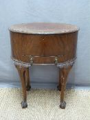 A 19th / 20thC oval mahogany work table with hinged lid, raised on cabriole legs,
