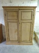 An antique pine panelled housekeeper's cupboard with facility for shelving or hanging space within,