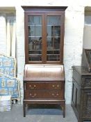 A glazed bureau bookcase with fitted interior inset leather fall flap and adjustable dogs tooth
