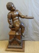 A 19thC carved oak cherub holding a platter, on square carved base,