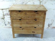 A pine chest of three straight drawers with finger apertures for opening,