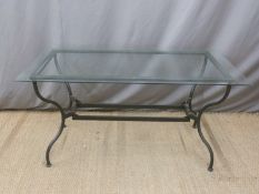 A glass topped dining table with metal legs suitable for indoor or outdoor use,