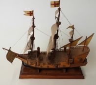A hand built wooden model of an Elizabethan galleon on wooden plinth,