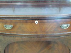 A 19thC James Shoolbred serpentine fronted mahogany sideboard raised on eight tapering legs with