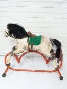 Tri-ang painted metal rocking horse on red base,