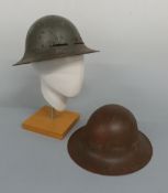 Two WWII British helmets, one with label Town Clerk, Poplar Town Hall,
