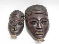 A pair of African carved rosewood tribal masks, purchased in mid-1940s, largest 23.