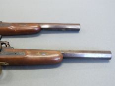 A pair of percussion hammer action pistols with chequered grip, ornate engraving to the locks,