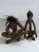 Two carved wooden tribal figures in sitting and squatting positions,