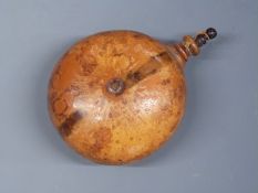 A powder flask in the form of a gourd with turned wooden stopper, 10cm long.
