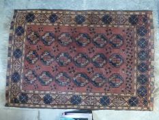 Small red ground hand made rug with blue and brown guls 100 x 150cm approx
