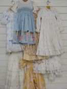 Seven dolls / children's dresses or part outfits some with lace decoration and printed patterns
