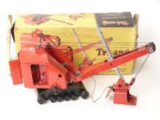 Tri-ang pressed steel excavator with red body, black base and black tracks, in original box.