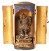 A 19thC Japanese wooden samurai warrior decorated with gilt detail in a lacquer two door cabinet