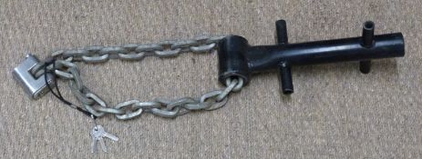 A metal ground anchor with chain and Viro padlock