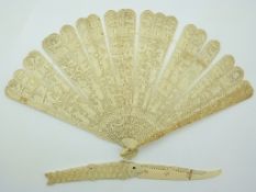 A 19thC Chinese carved ivory fan depicting court scenes and a fish shaped letter opener