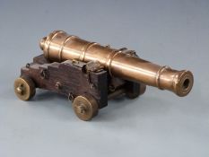 Signalling or display model cannon with 29cm graduated brass barrel raised on oak carriage,