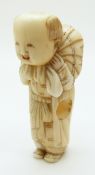 Japanese ivory netsuke depicting a man carrying a sack