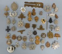 A collection of military cap badges including Royal Scots, County of London,