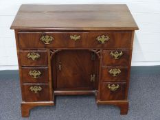 18th/19thC mahogany oyster veneer desk with central cupboard and an arrangement of seven drawers