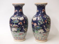A pair of Chinese vases decorated with bird, insects and flowers with seal mark to base,