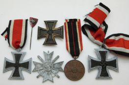 German WWII medals comprising three Iron Crosses, a War Merit Medal with ribbon,