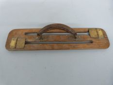 A wooden and brass game carrier with leather handle,