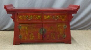 A Chinese sideboard with a red ground and lacquer decoration depiciting figures,