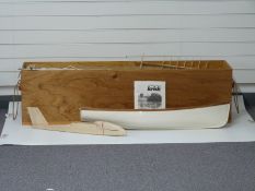 A large colection of wooden aeroplane and boat model kit parts in a wooden chest with rope handles