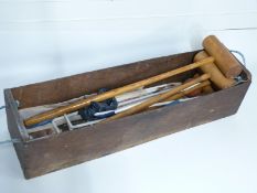 Vintage croquet set in wooden carry box with rope handles.