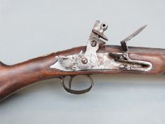 Flintlock hammer action gun with brass trigger guard, butt plate and mounts, wooden ramrod,