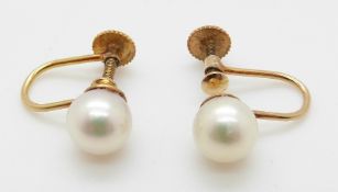 A pair of 9ct gold earrings set with a pearl to each,