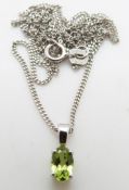 A 9ct white gold pendant set with a peridot and a 9ct white gold chain, 2.
