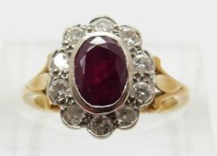 An 18ct gold ring set with an oval cut ruby of approximately 1ct surrounded by round cut diamonds,