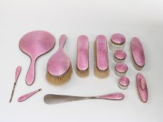 George V pink guilloché enamel dressing table set comprising hand mirror, three brushes,