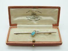 A 9ct gold brooch set with an opal doublet and two diamonds with a platinum finish,