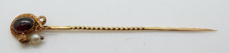 Victorian stick pin set with a foiled garnet surrounded by a snake with a pearl drop from its mouth,