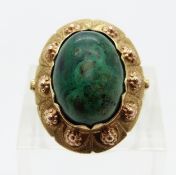 A 14k gold ring set with an azurite cabochon and textured detail to the border,