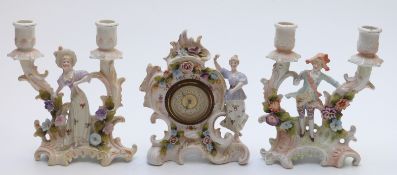 A late Victorian continental garniture comprising a clock with figurine and two double candlestick