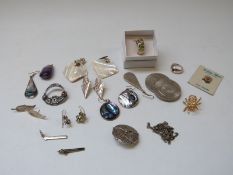 A silver ring set with peridot and matching earrings, a silver brooch,