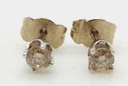 A pair of 14k white gold earrings each set with a round cut diamond of approximately 0.