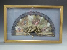 A framed and glazed fan with lace trim,