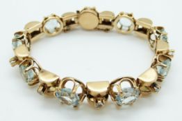 An 18ct gold bracelet set with nine large and nine small round mixed cut aquamarines,